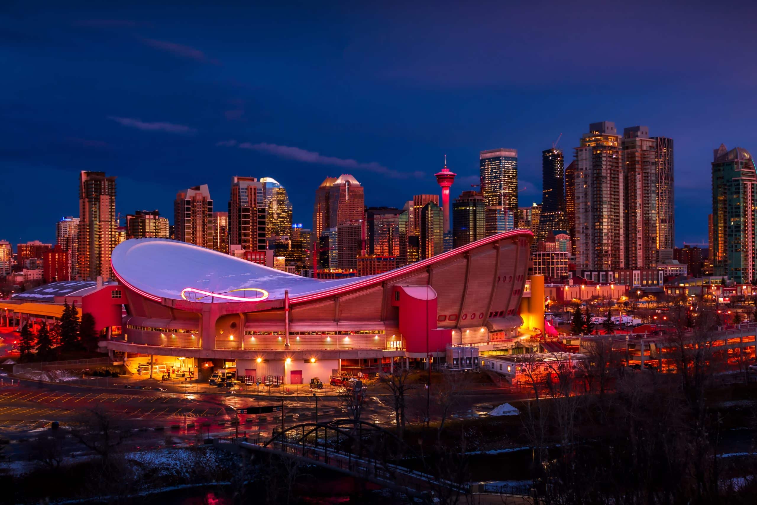 Scotiabank Saddledome en skyline van Calgary bij avond