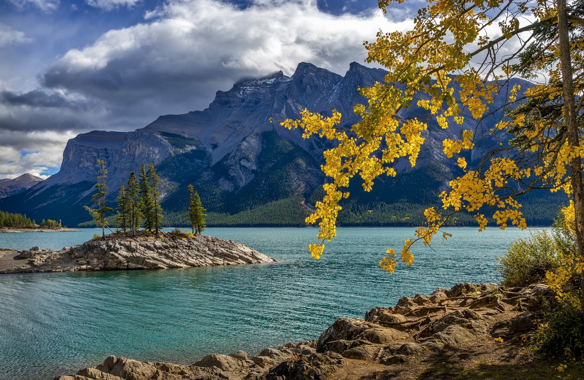 Banff National Park met bergmeer, rotseiland en gele herfstbladeren.