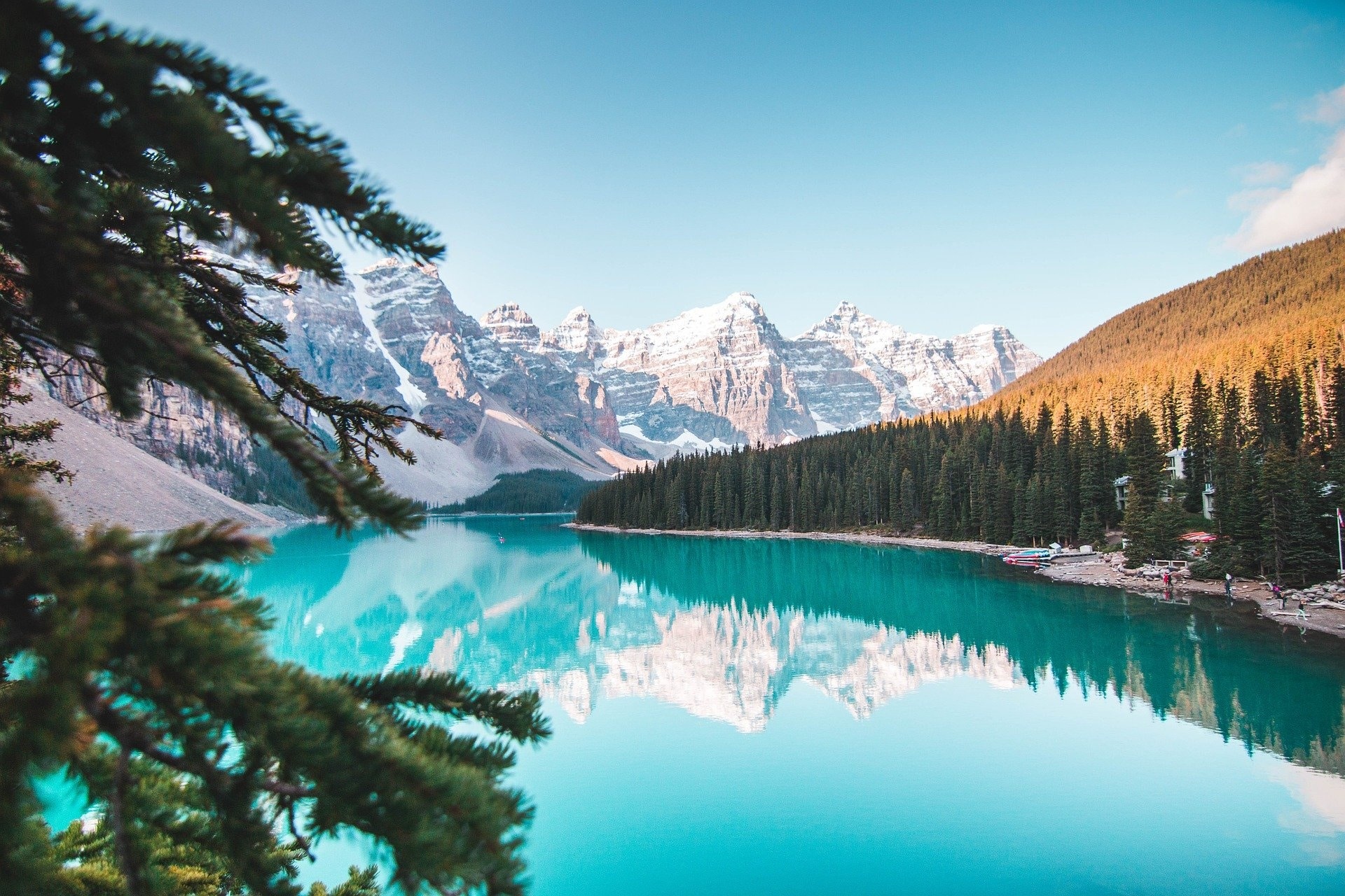 Moraine Lake in Alberta met turquoise water, bos en besneeuwde bergtoppen.